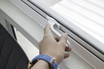 Close-up of man hand on window