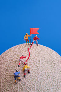 Low angle view of people against blue sky