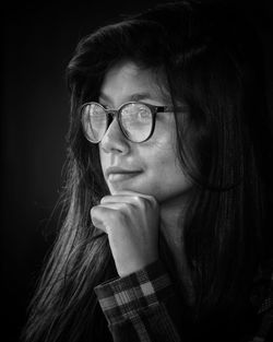 Young woman with long hair against black background