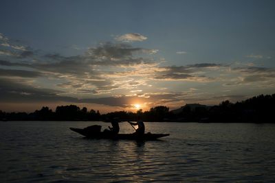 Silhouette of boat in sea during sunset