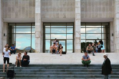 People on steps against building