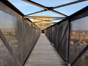 Empty footbridge against sky