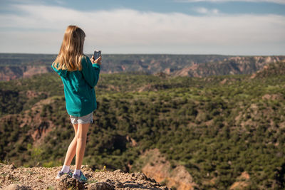 Rear view of woman standing on mountain