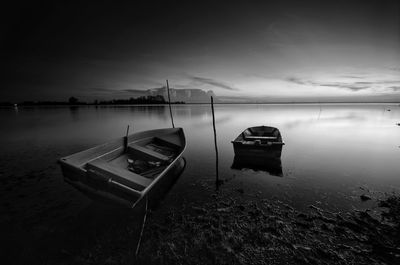 Boat moored on beach against sky