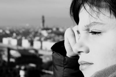 Close-up side view of boy looking away in city