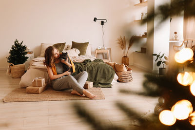 Rear view of woman sitting on sofa at home