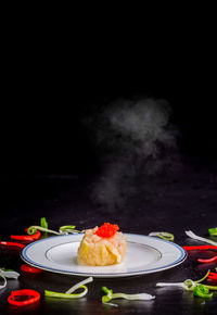 Close-up of cake on plate against black background