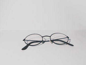 Close-up of eyeglasses on table against white background