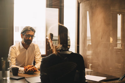 Mature client listening to female lawyer in office meeting