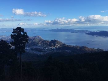 Scenic view of sea and mountains against blue sky