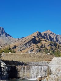 High angle view of dam and mountains against clear blue sky