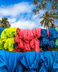 Low angle view of multi colored umbrellas against blue sky