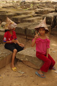 Full length portrait of girl wearing hat on rock