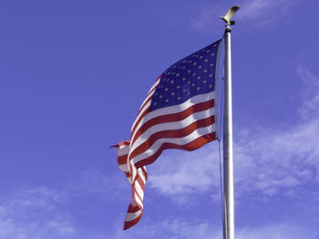 Low angle view of flag against blue sky