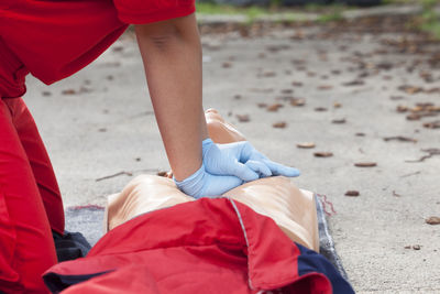 Midsection of paramedic performing cpr on mannequin