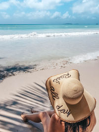 Man wearing hat on beach against sky