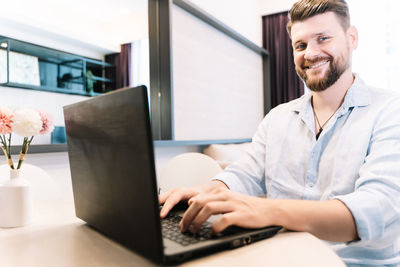Man using mobile phone while sitting on table