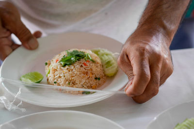 Midsection of man having food in plate