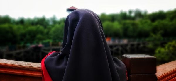 Rear view of person wearing sunglasses against trees