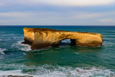 Rock formation in sea against sky