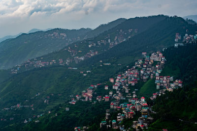 Aerial view of townscape and mountains against sky