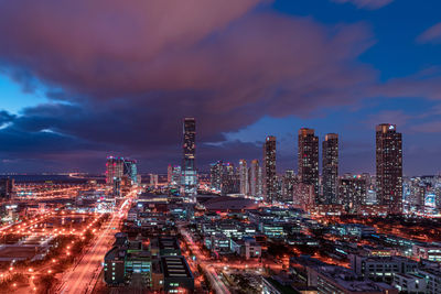 Illuminated cityscape against sky at dusk