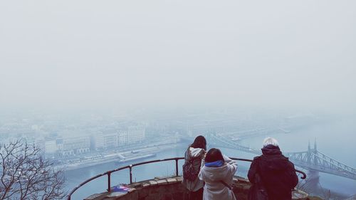 Rear view of women in winter against sky