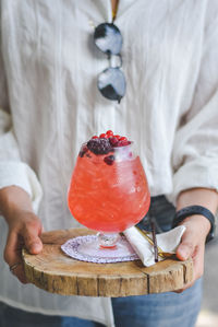 Midsection of woman holding iced strawberry soda