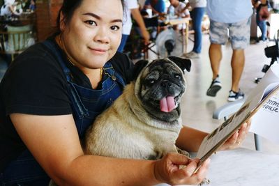 Portrait of woman with pug holding menu