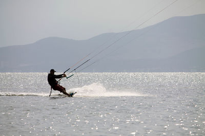 Man surfing in sea against clear sky