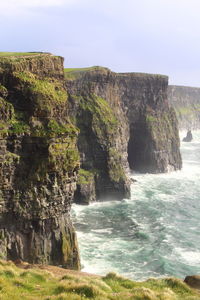 Scenic view of rock formation by sea against sky