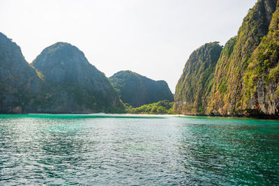 Scenic view of sea and mountains against clear sky