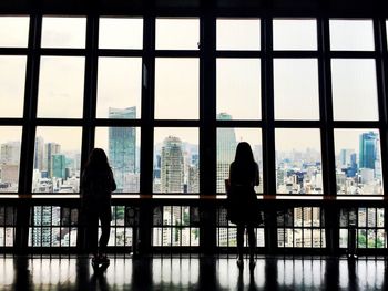 Rear view of women looking through window