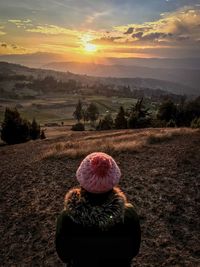 Rear view of woman on field during sunset