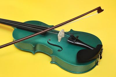 Close-up of violin against yellow background