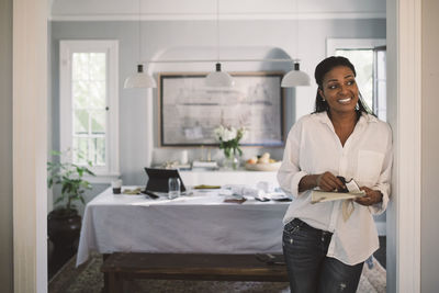 Portrait of smiling young woman standing at home