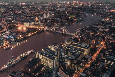 High angle view of illuminated city buildings by river
