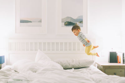 Boy playing on bed at home