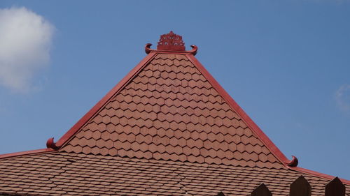 Low angle view of building roof against sky