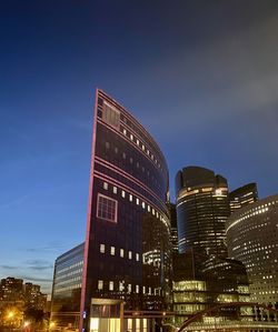 Low angle view of illuminated buildings against blue sky