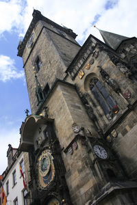 Low angle view of clock tower amidst buildings against sky