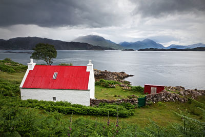 Scenic view of lake by buildings against sky