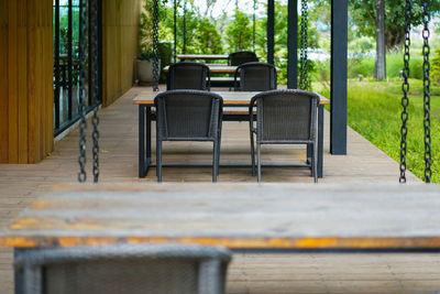 Empty chairs and table against trees
