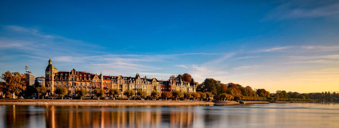 River by buildings against sky