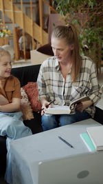 Portrait of smiling woman using laptop at table