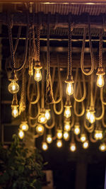 Low angle view of illuminated light bulbs hanging from ceiling