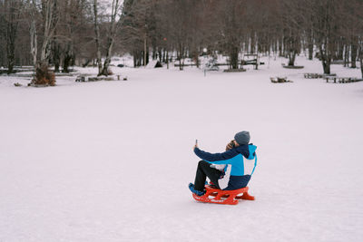 High angle view of woman skiing on snow covered field