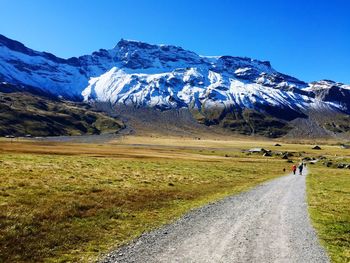 Scenic view of snowcapped mountains against clear blue sky