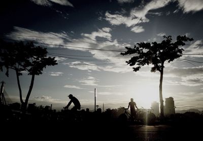 Silhouette trees against cloudy sky