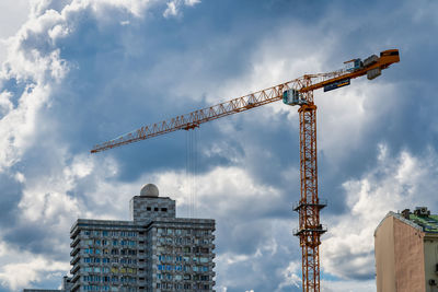 Low angle view of crane against sky